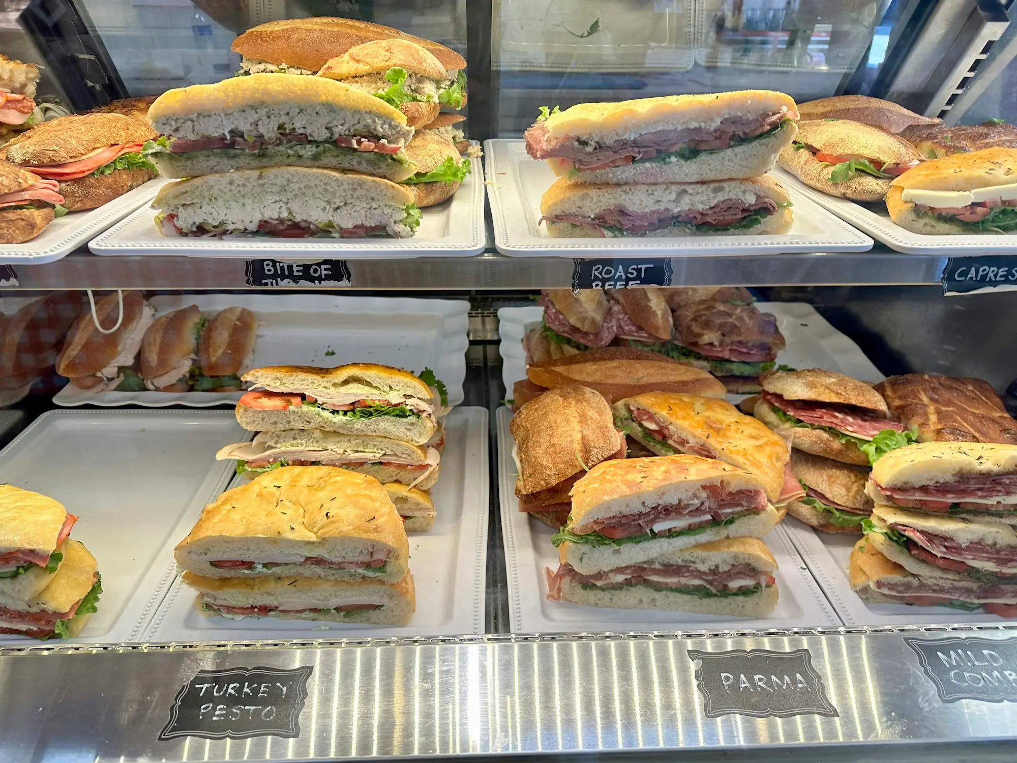 Deli display cabinet stocked with sandwiches and fresh food
