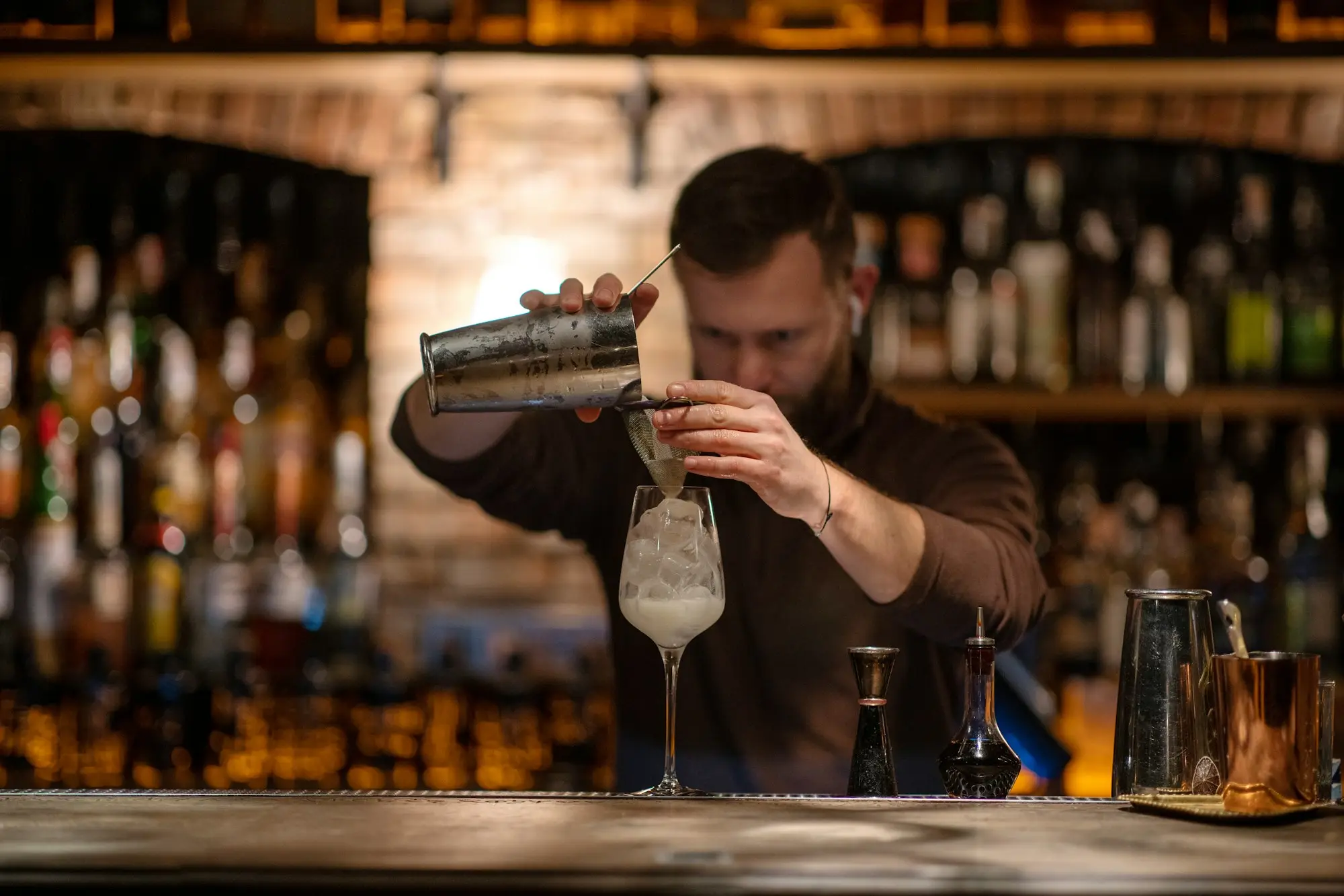 Bartender preparing drinks behind a small bar counter