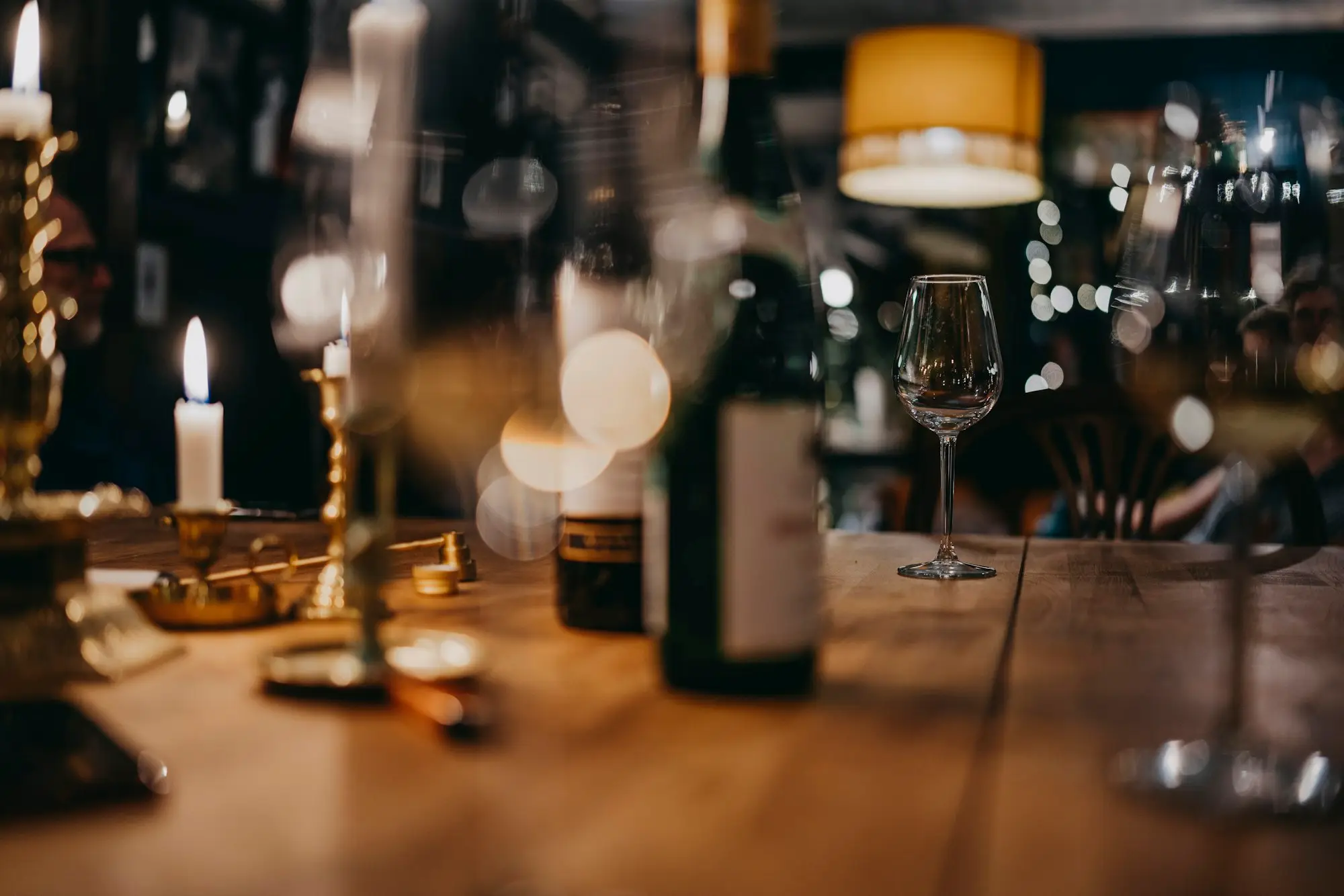 Candlelit table in a wine bar with glasses and a bottle